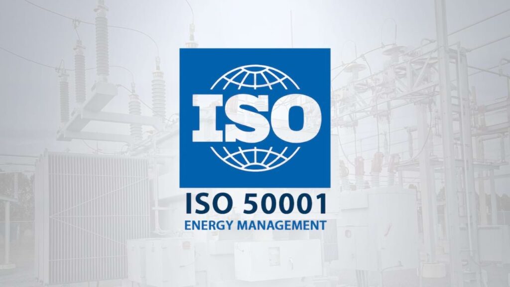 Logotipo da norma ISO 50001 em destaque sobre fundo com subestação elétrica, representando práticas de gestão de energia em ambientes industriais.